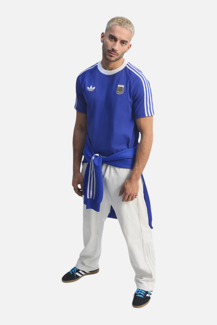 Adidas Argentina Originals Tee in Lucid Blue styled with white trousers — full body
