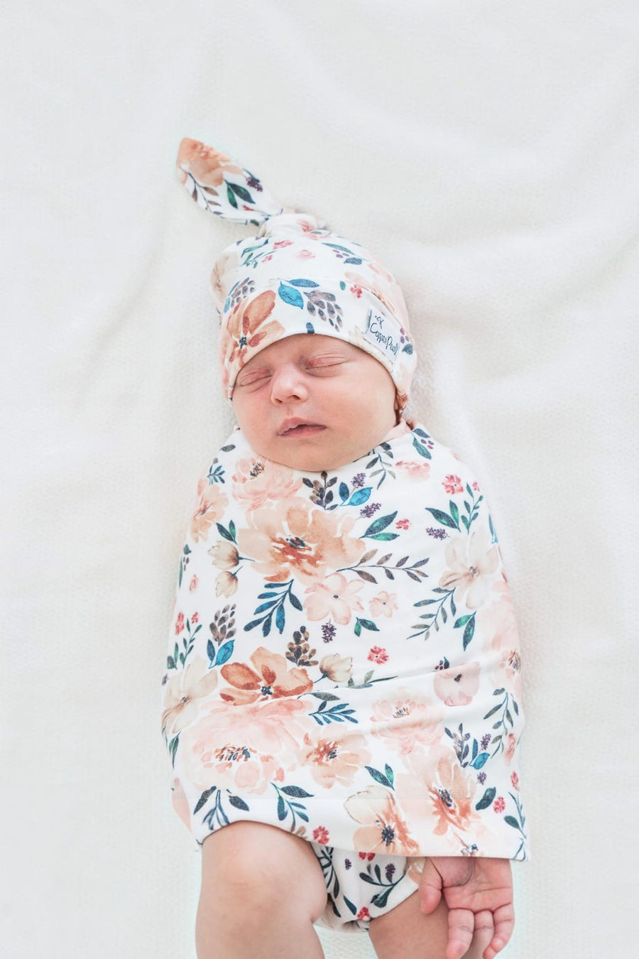 Copper Pearl Autumn swaddle blanket wrapped around a baby.