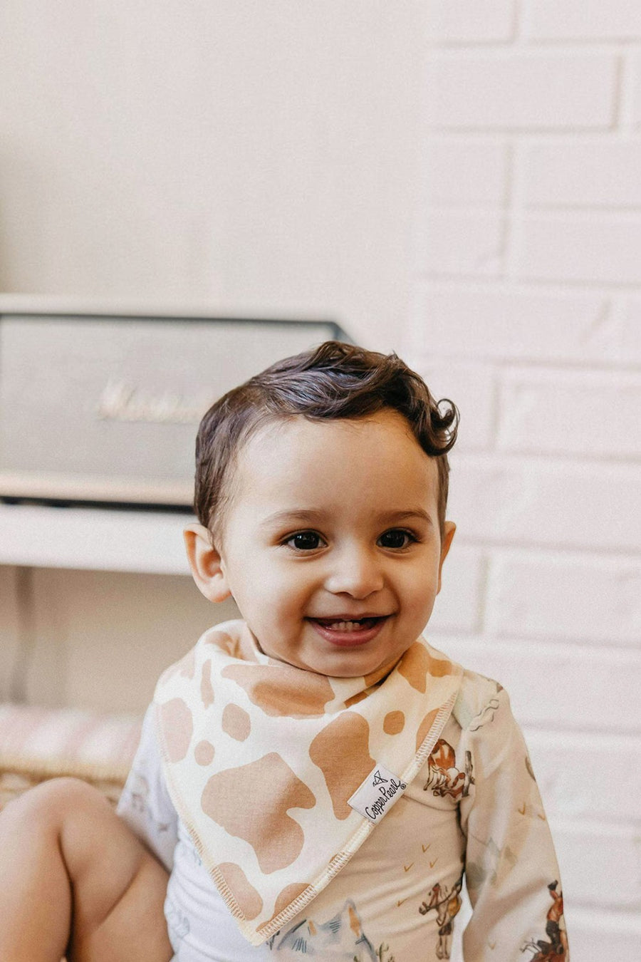 Copper Pearl Boone baby bandana bib worn by a baby.