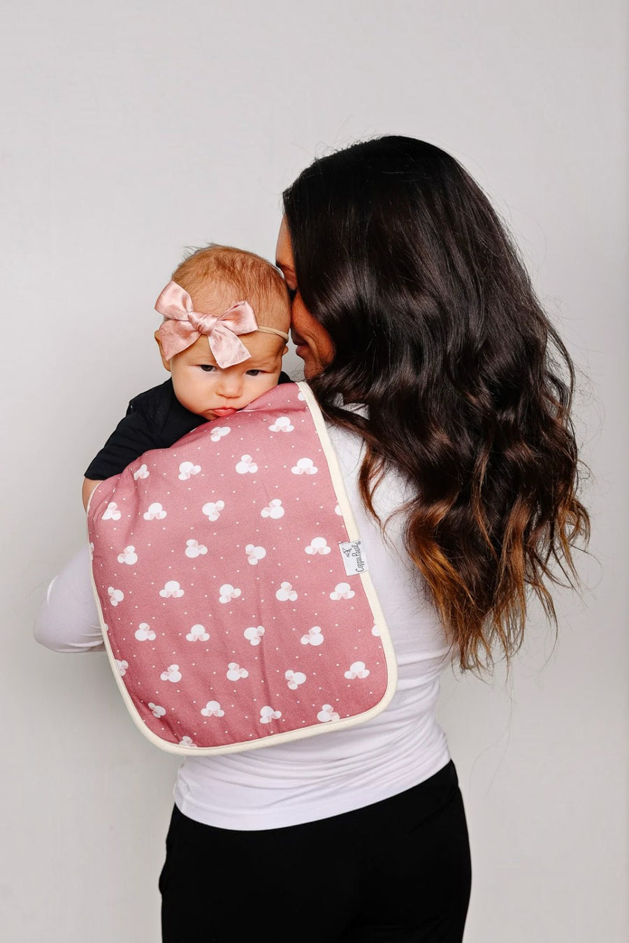 Copper Pearl Minnie Mouse burp cloth shown draped over a shoulder.