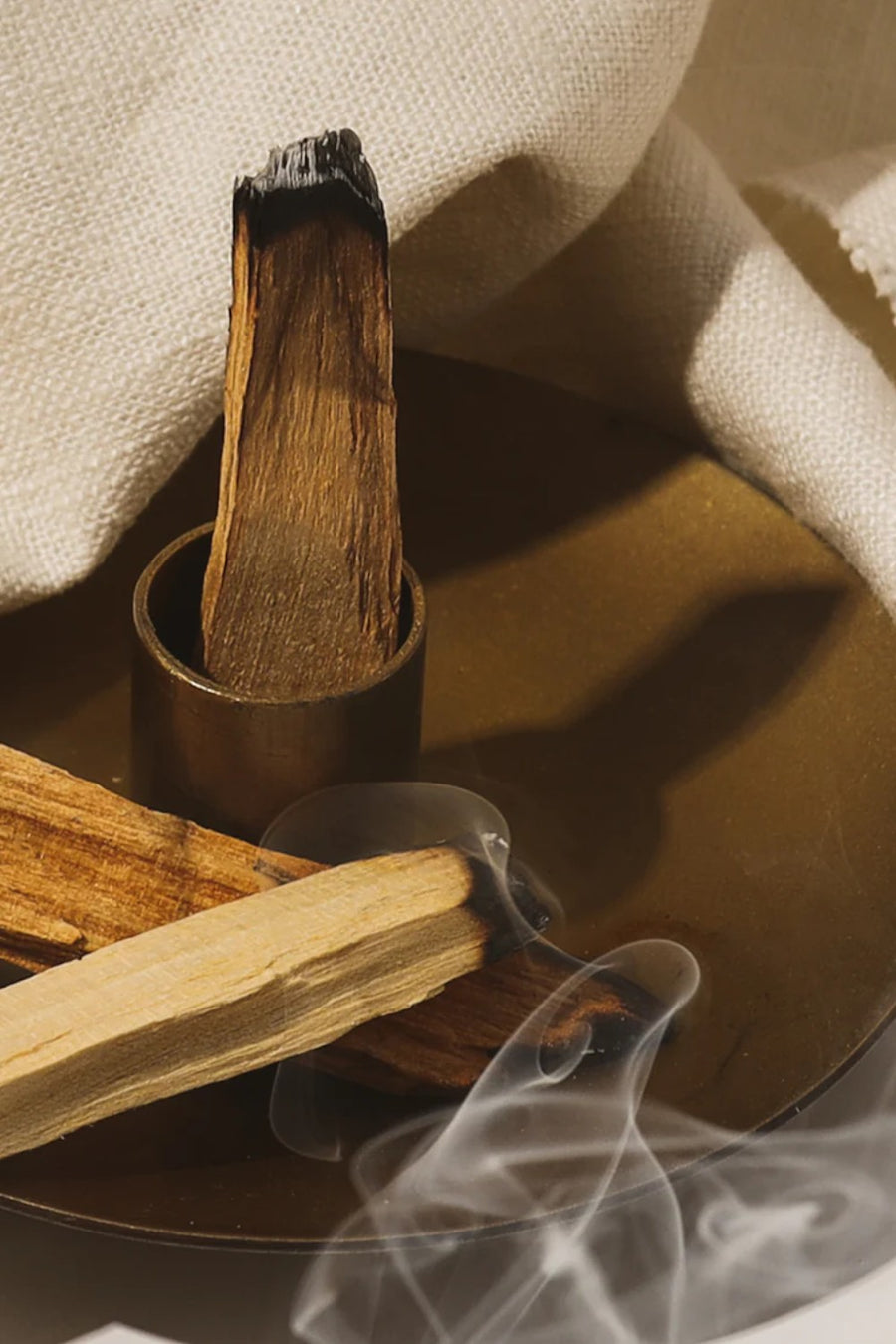 Palo santo sticks with smoke on a neutral background