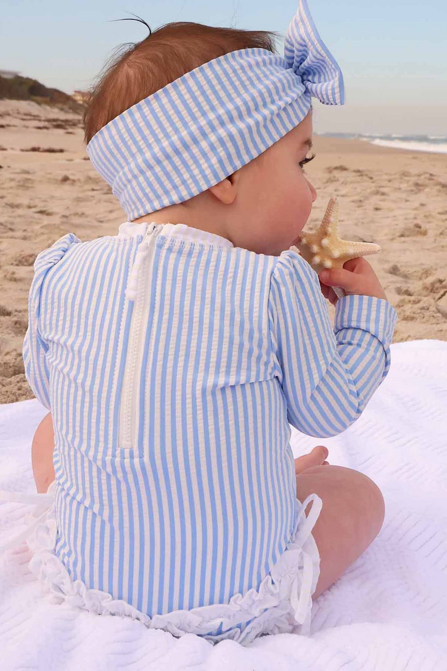Caden Lane Long Sleeve Rash Guard with Ruffle Bottom in Seersucker Blue – flat lay