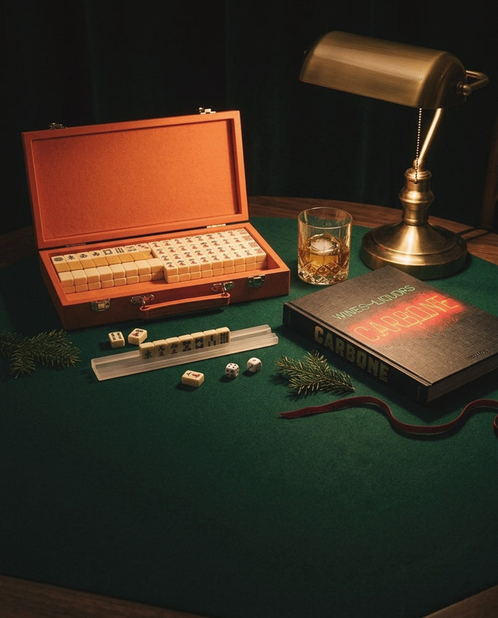 Holiday gifts under $250: Brouk & Co. mini travel mahjong set and the Assouline Carbone book on a green card table