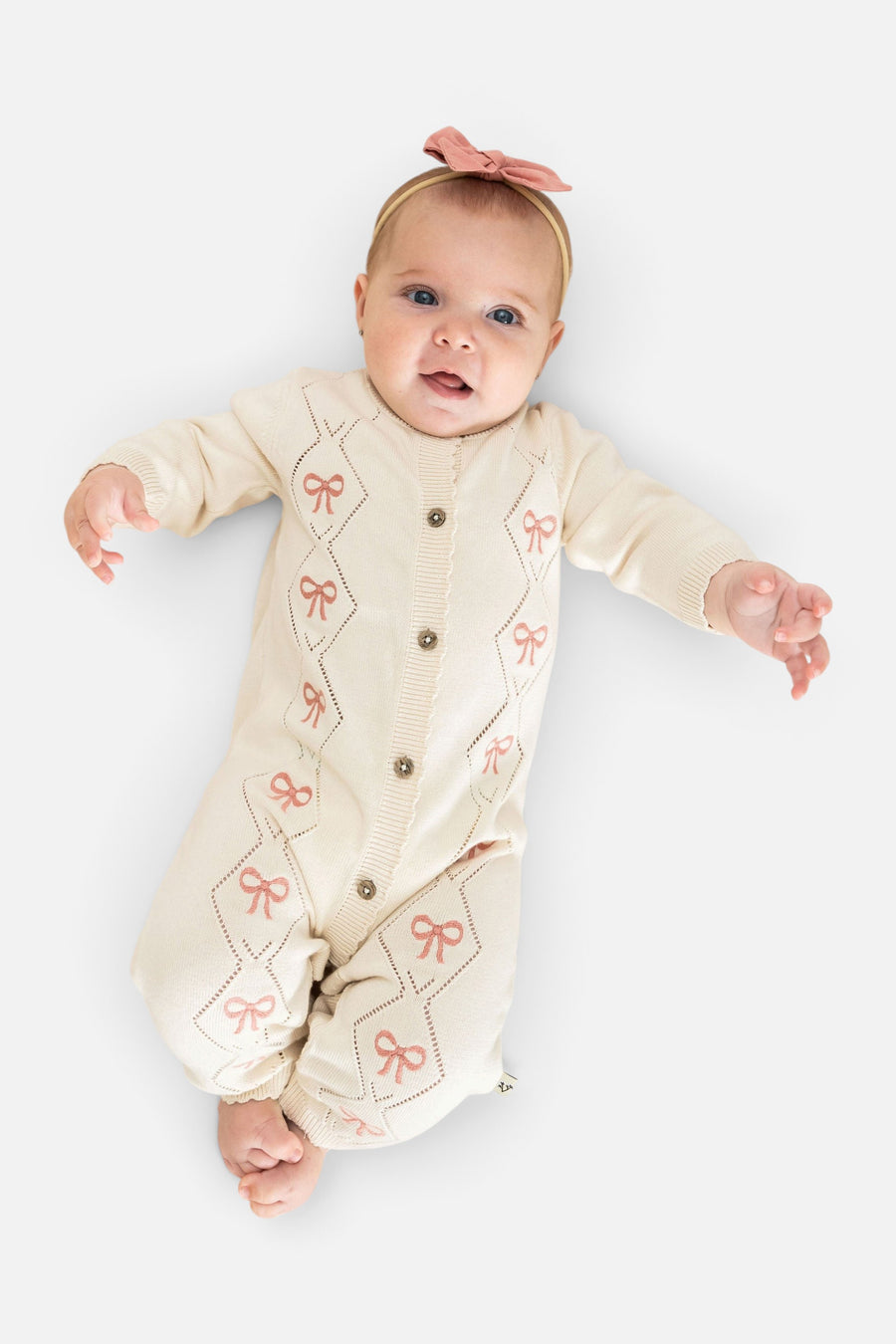 Evie Bow Pointelle Knit Baby Jumpsuit in Ecru – on model