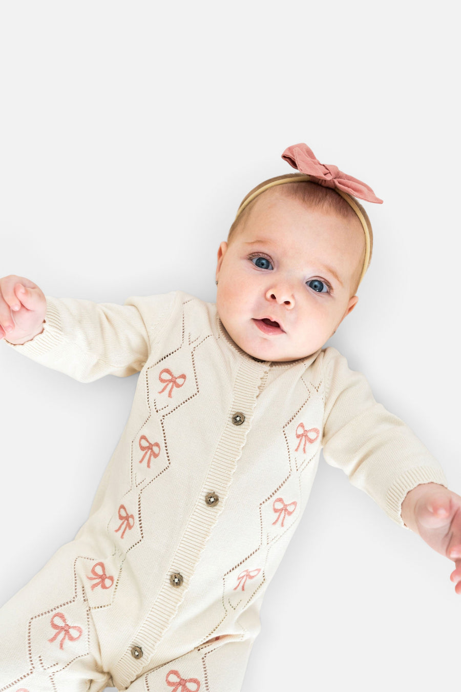 Evie Bow Pointelle Knit Baby Jumpsuit in Ecru – on model