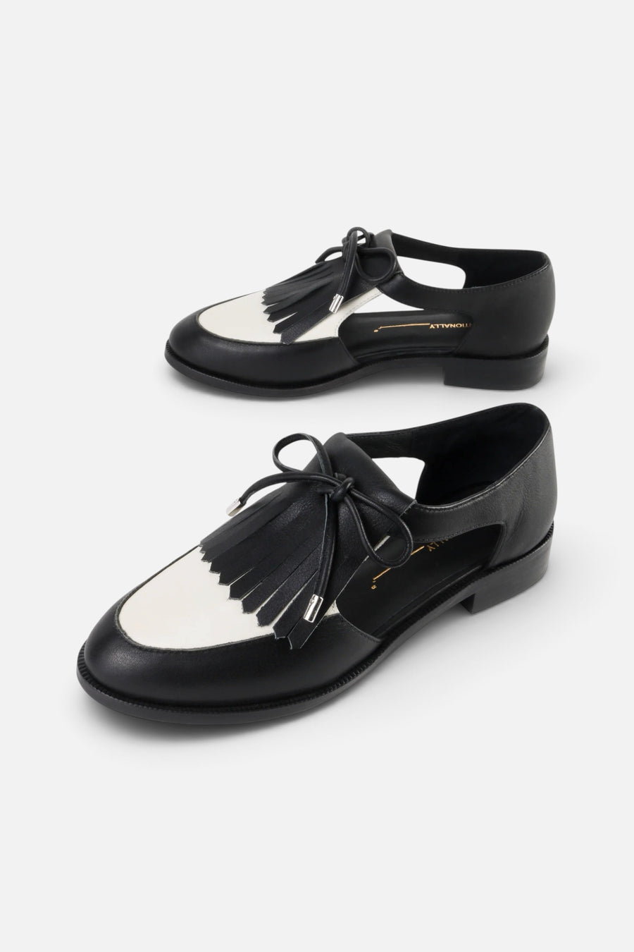 Intentionally Blank Tock Cutout Tassel Oxford in Black White – front view